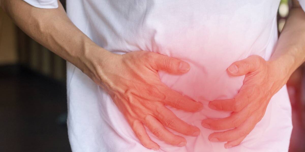Man clutching lower abdomen from pain of a surprise hernia.