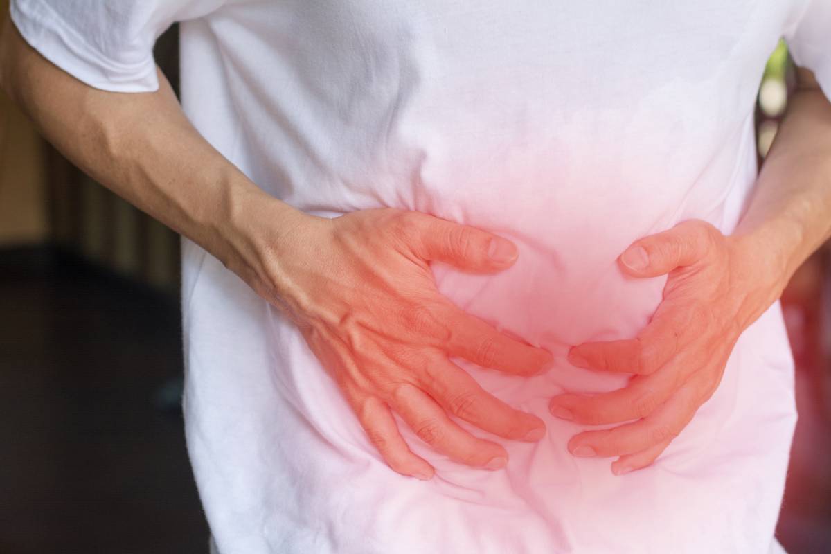 Man clutching lower abdomen from pain of a surprise hernia.